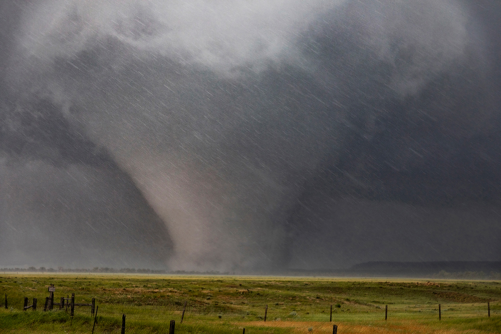 a monster wedge-shaped tornado surrounded by hail