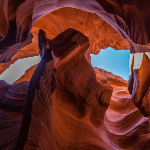 A sliver of blue sky can be seen above the slot canyon